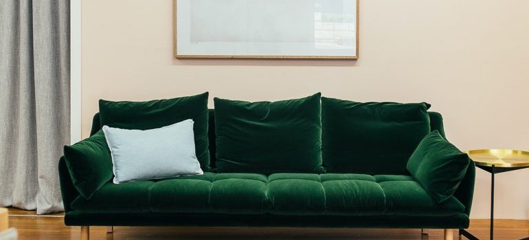 Green velvet three-seat sofa that would stand on end when loading a moving truck like a pro