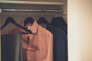 Clothes on hangers in a wardrobe after unpacking and organizing clothes