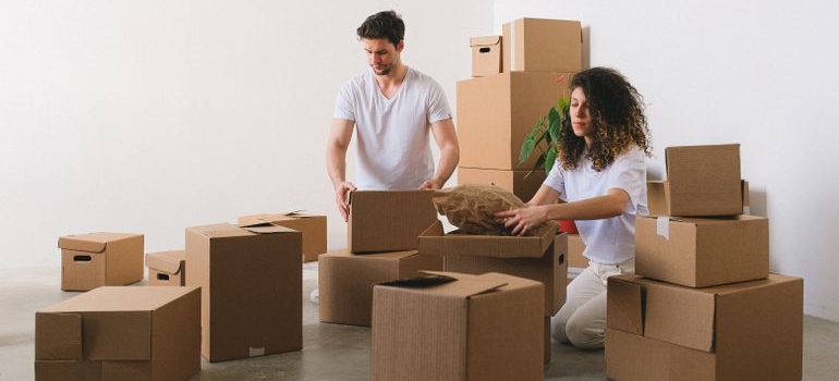 a couple packing moving boxes