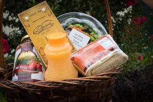 A gift basket containing sambosa, green salad, fancy chocolate, marinara sauce and fresh orange juice is a great way to treat friends who help you move.
