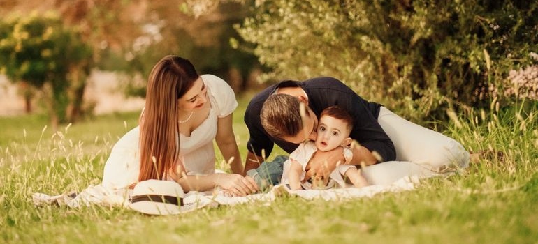 Parents playing with their baby on the grass in a park