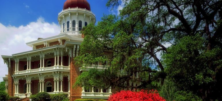 Octagonal antebellum mansion with a red onion dome, live oaks, and red azaleas in Mississippi