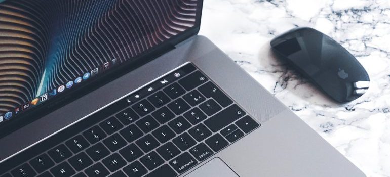 A laptop with a mouse next to it on the desk 