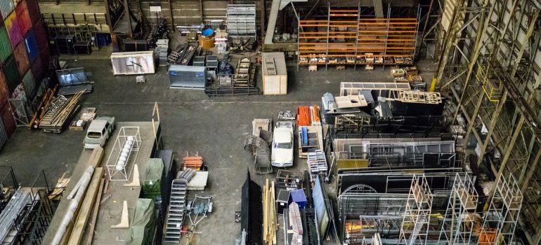 Overhead view of a large warehouse floor with equipment, racks and a parked car