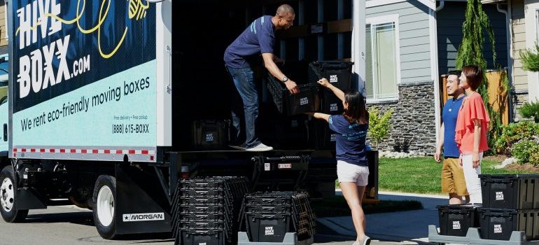 Four people packing things into the truck 