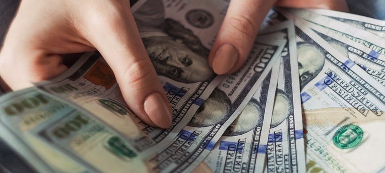 a person holding 100 dollar bills
