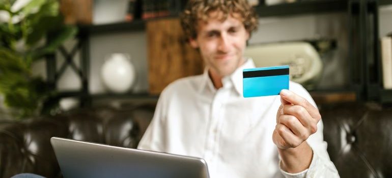 A man holding a credit card while paying online