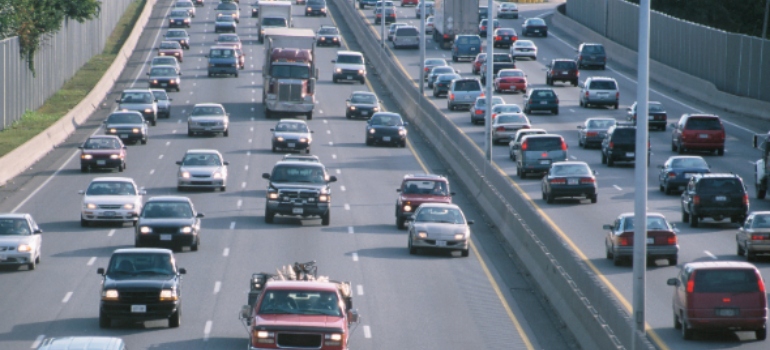 Heavy traffic of cars and a semi truck on a multi-lane divided freeway