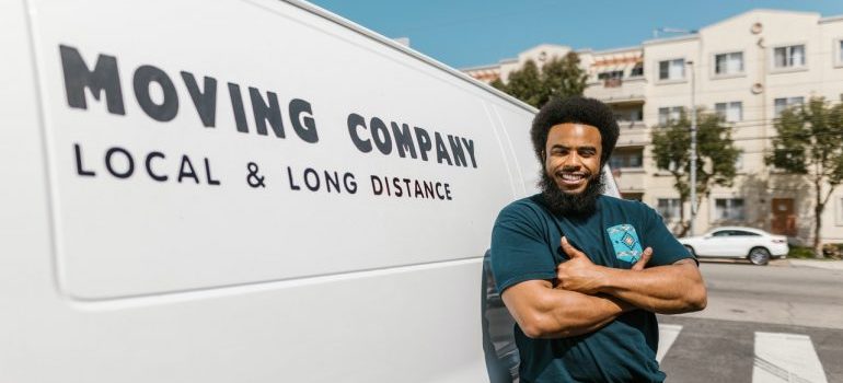A mover standing next to a marked moving company van