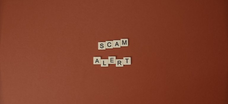 Letter tiles spelling scam alert, a reminder of the risks of hiring cheap movers