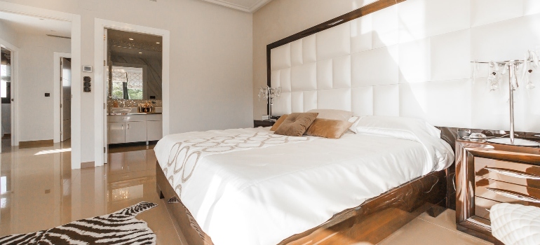 Wooden bed frame with white cover with kitchen elements and other spaces that you enjoy living in a loft.