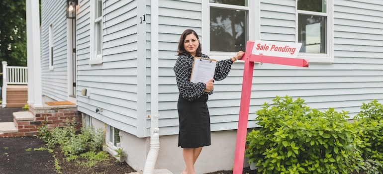 A Broker Standing Beside a Sign.