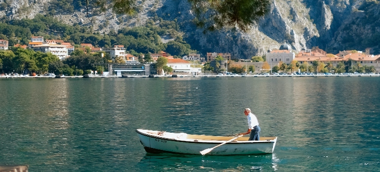 Man rowing a small boat on a calm lake