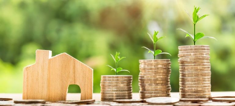 a wooden house and three piles of coins