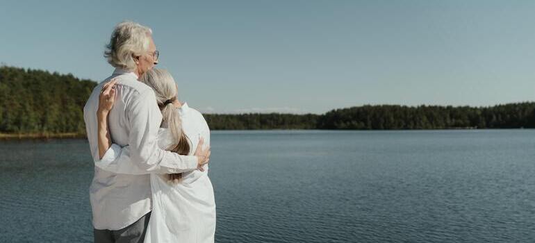 older couple is hugging near water