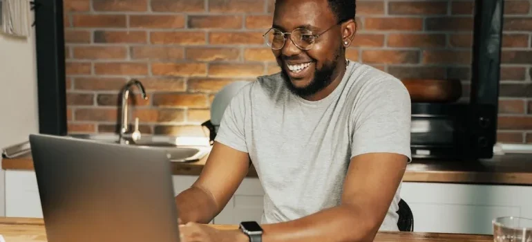 A smiling man working on his laptop