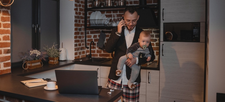 Man looking for the best TN cities for job seekers while holding a baby