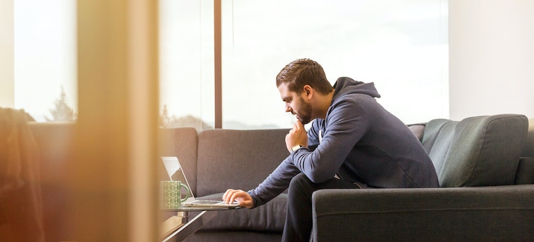 a man reading on a laptop about Mississippi vs Tennessee
