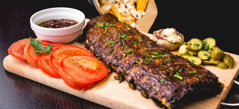 Steak on a wooden platter, representing an impressive dining scene that's one of the fun facts about Tupelo