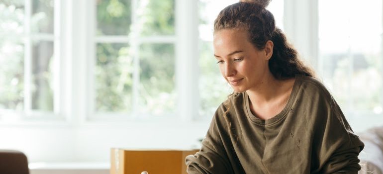 Woman sitting by a bright window after a move, ready for a fresh start in Colorado