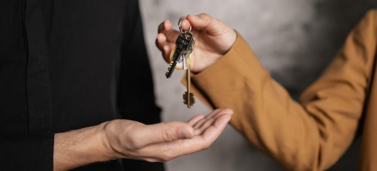 person giving a key to another person