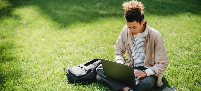 A person working on a laptop in a park in one of the top TN cities for digital nomads