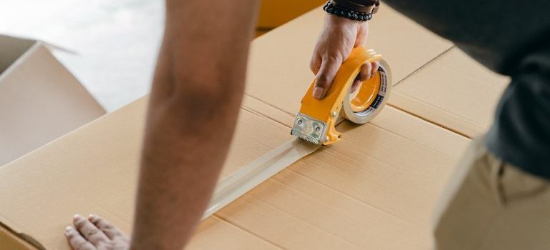 A man preparing moving boxes so unpacking clothes is easier later