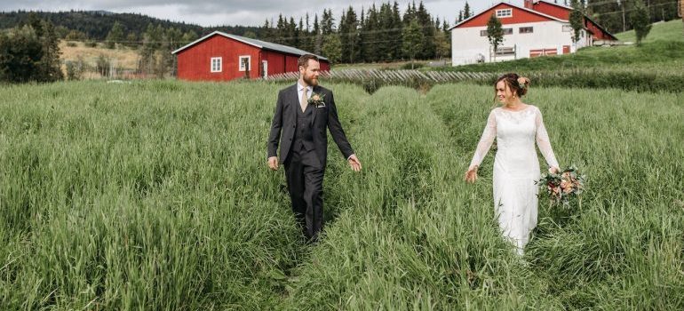 Bride and groom standing together in an open field