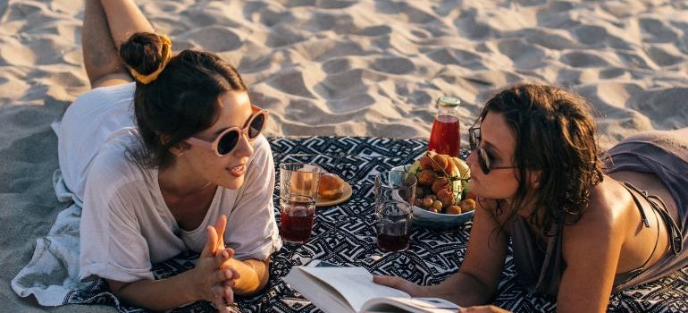 two women having a picnic on the beach in Gulfport, one of the ideal places in Mississippi for singles 