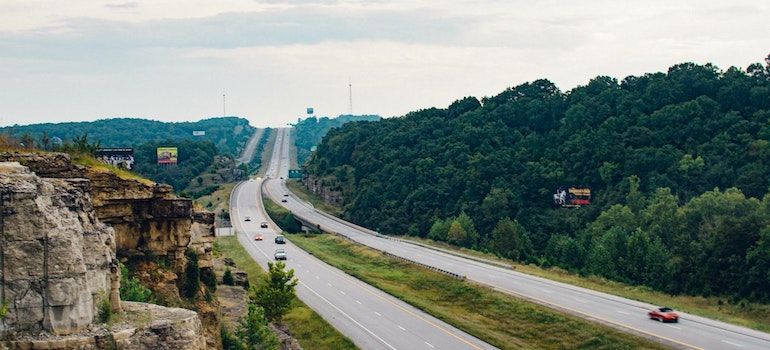 Highway with cars and trees at sunset
