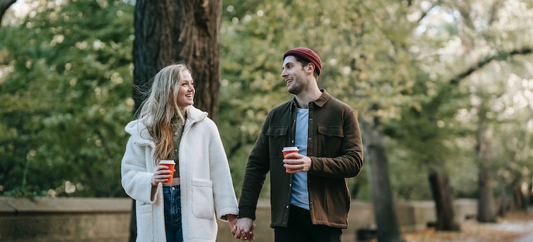 A couple taking a walk along a tree-lined park path