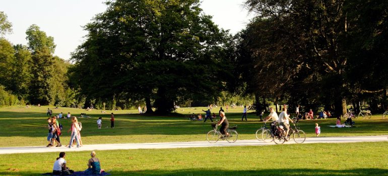 People sitting on the grass in a city park, one of the spots to relax in Denver after the move