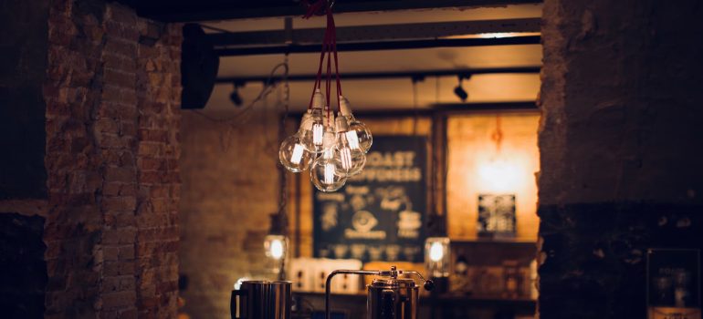 Warm hanging string lights over a wooden coffee shop interior