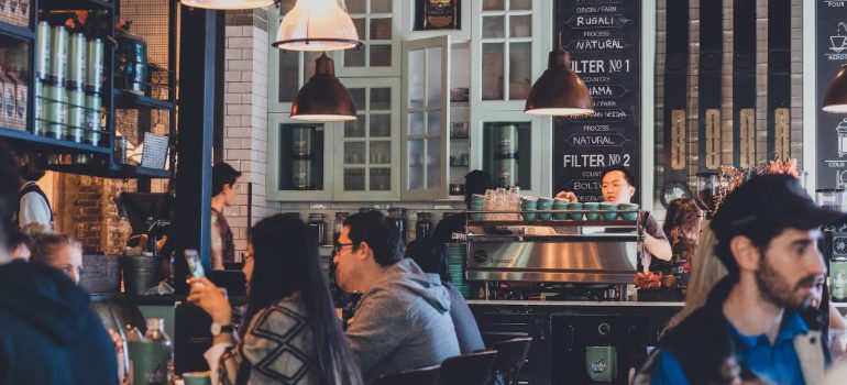 People talking over coffee at tables inside a busy coffee shop