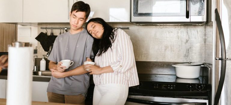 A couple drinking coffee in the kitchen of their new home