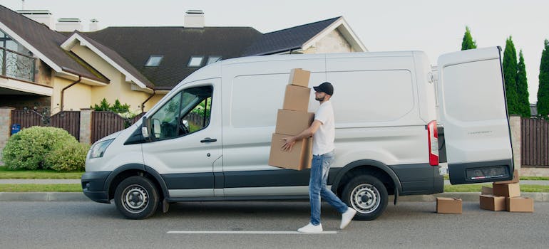 A professional mover carrying boxes from a van