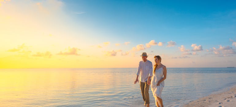 A young couple walking together on a sandy beach