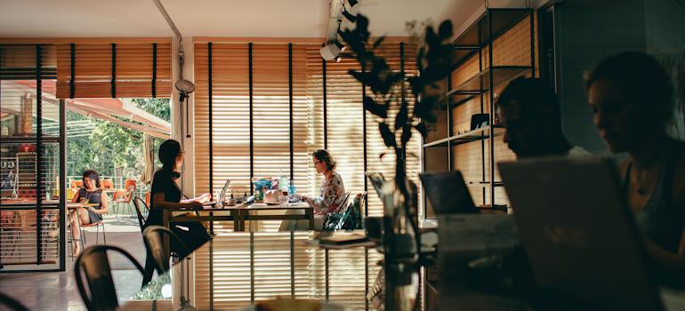 People using their laptops to research the best Denver spots for college students at a coffee shop