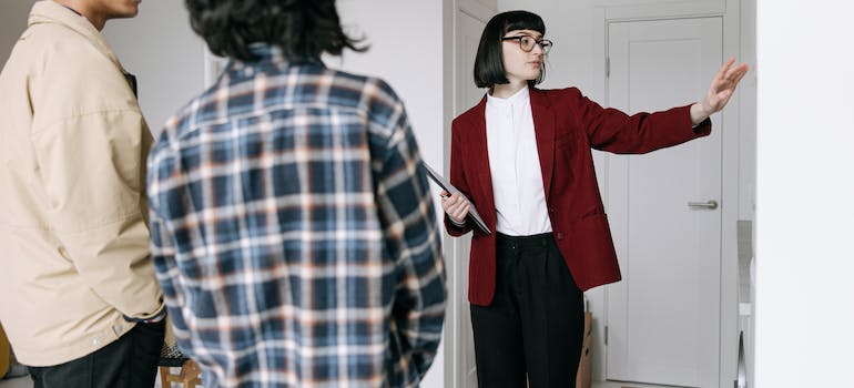 A real estate agent showing a young couple around a home in one of the places in Mississippi for young professionals