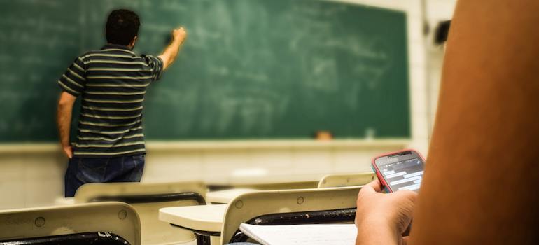 A teacher at a school in Greenwood Village writing on a blackboard