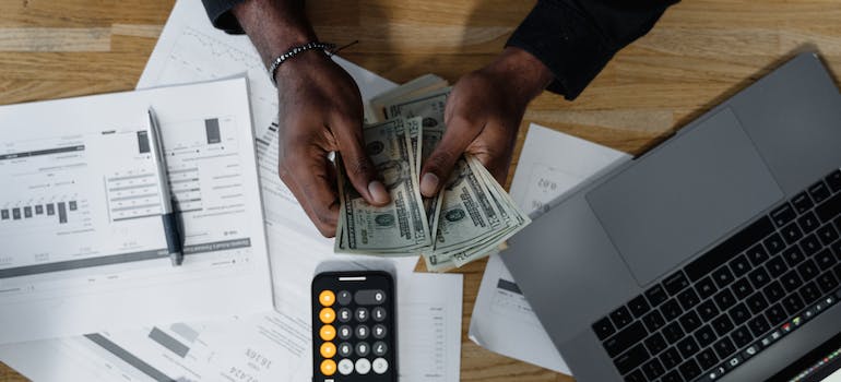 A person counting cash and budgeting a move to one of the Mississippi places for young couples