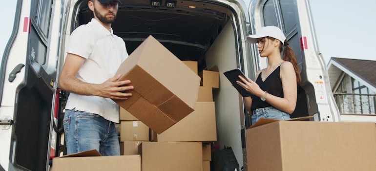 Movers loading packed boxes into a moving van