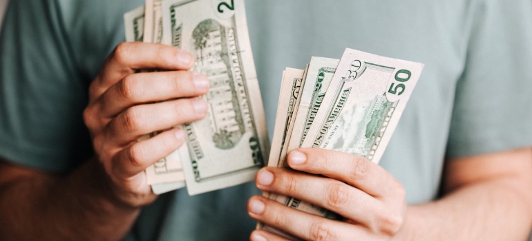 A person counting money for moving to one of the Colorado cities for small business owners