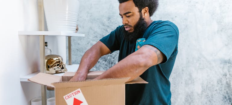 Mover taping and stacking cardboard moving boxes