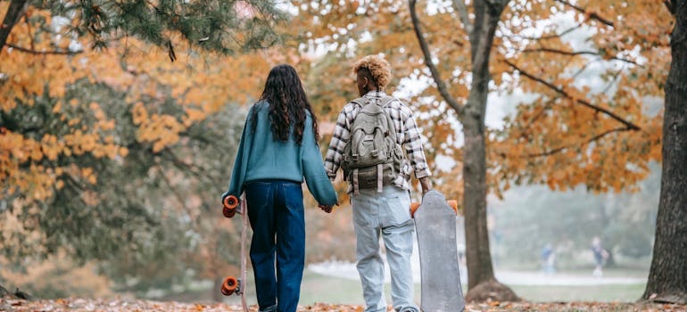 A couple walking in a park among fall foliage