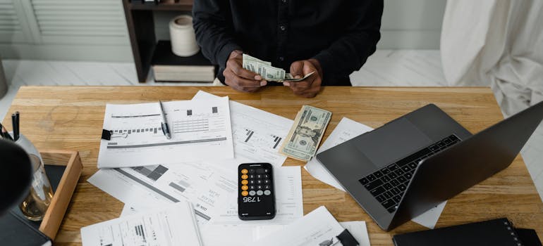 A person counting cash while budgeting for moving from Arvada to Broomfield CO