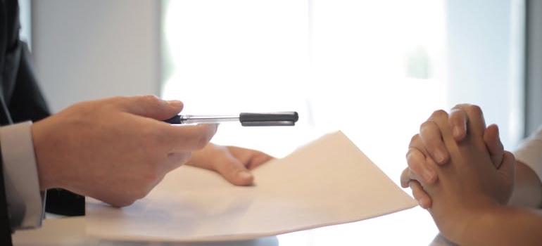 A person handing someone a contract
