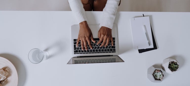 A person comparing cities on a laptop at home