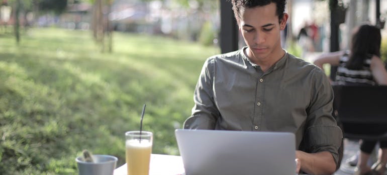 A person researching on a laptop whether to buy a home in Denver right now