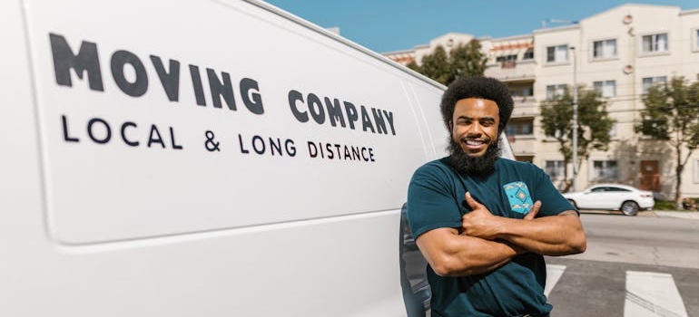 A mover leaning against a van